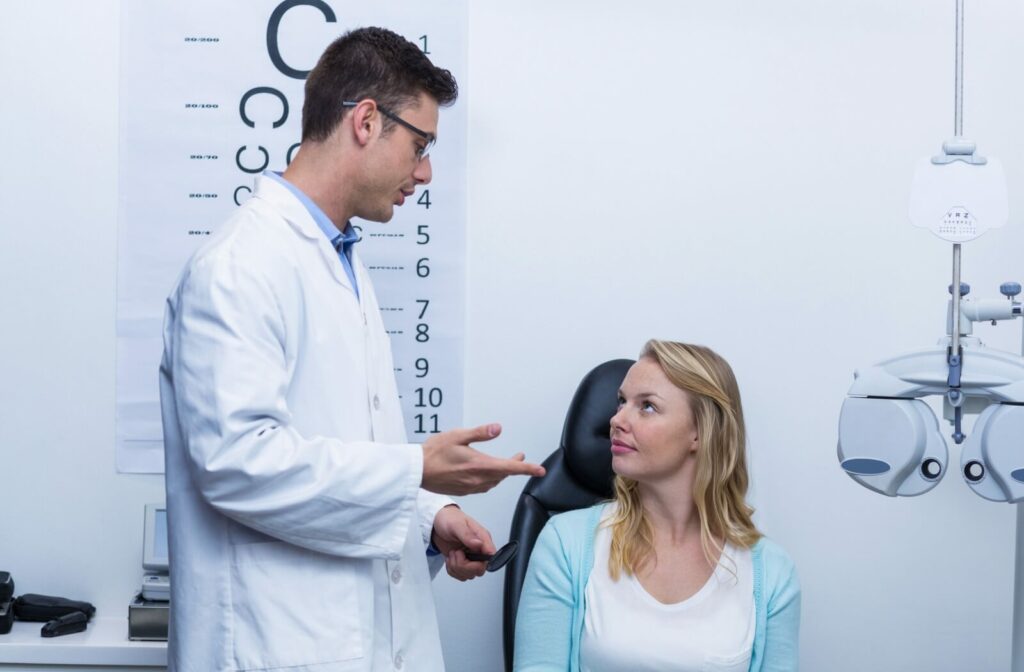 An optometrist talking to his patient in an exam room.