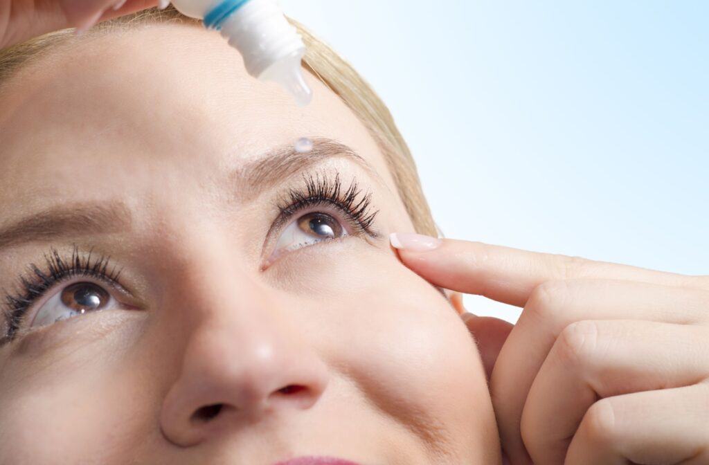 A close up image of a person dropping some eye drop solution in their eye to provide relief from their eye strain.