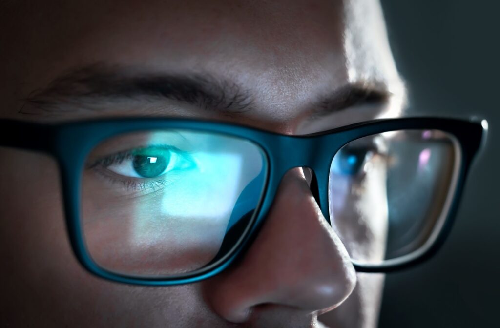 Close-up of a computer screen reflecting off someone's glasses.