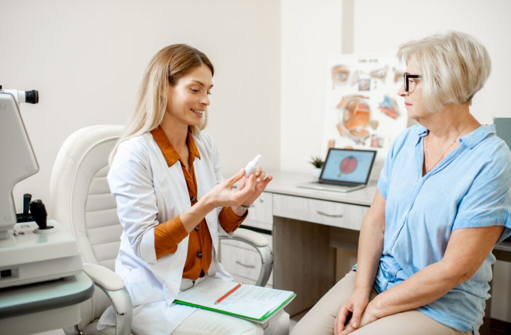 An eye doctor recommending eye drops to a patient in the exam room.
