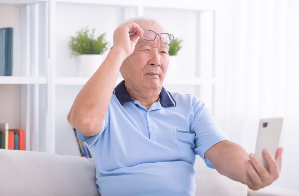 A man with presbyopia holding out his phone to be able to see what's on the screen.